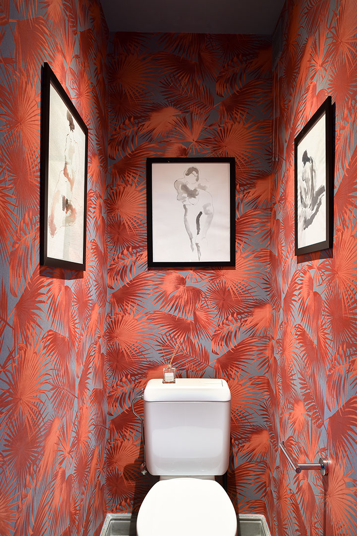Een toilet in een artistieke sfeer, behang met plantmotief